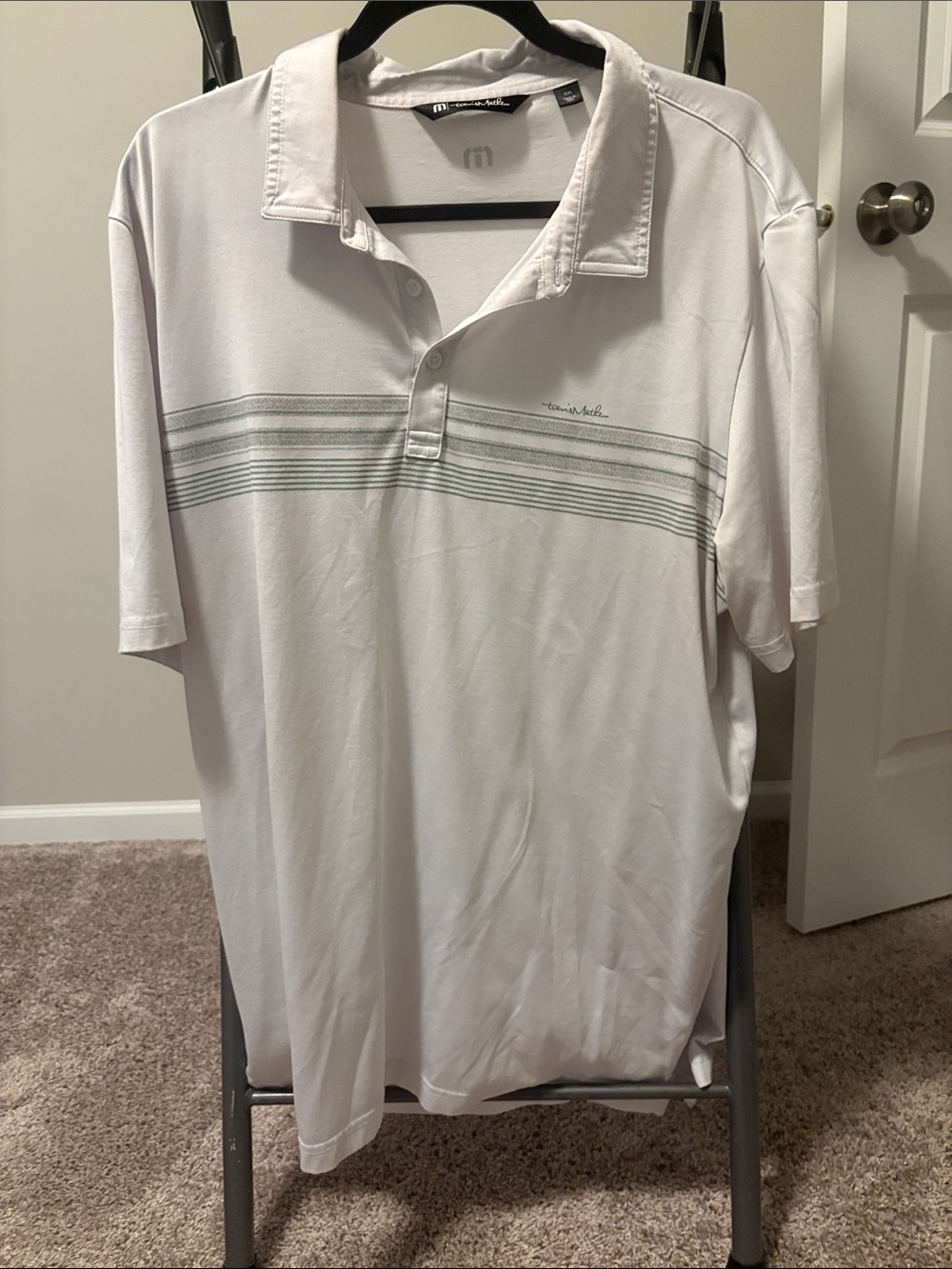 Travis Mathew White Polo with Subtle Gray-Green Chest Stripes